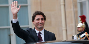 Kanadas Premierminister Trudeau hebt bei seiner Ankunft in paris grüßend die Hand