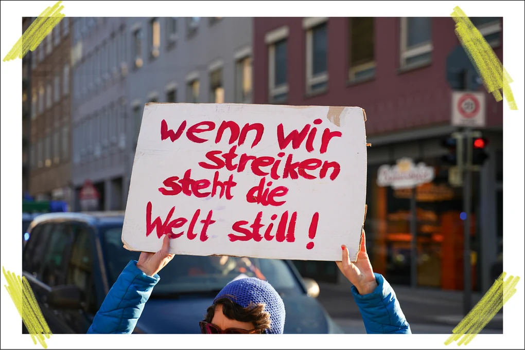 Eine Demonstrantin hält am Internationalen Frauentag 2025 ein Plakat hoch