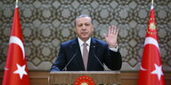 Erdoğan auf einem Rednerpult zwischen türkischen Fahnen