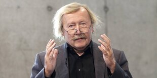 Sloterdijk guckt in die Kamera und hält die Hände als würde er einen Ball halten