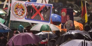 Regenschirme und Pegida-Plakate.