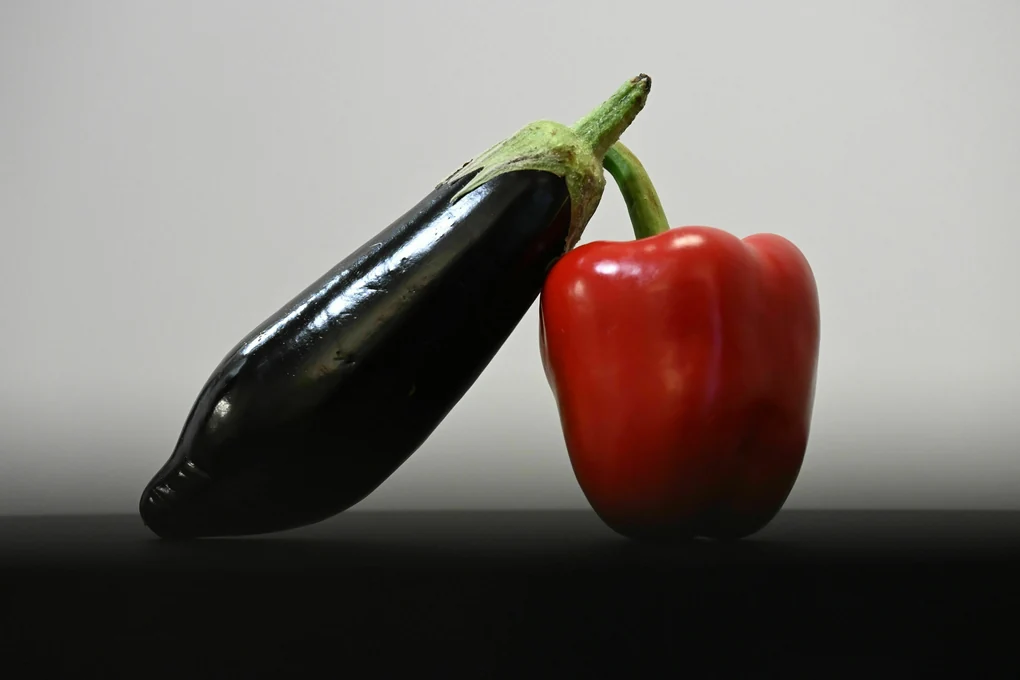 Eine schwarze Aubergine und eine rote Paprika