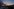 Städtische Skyline bei Sonnenuntergang mit Rauchsäule und Wolken am Himmel