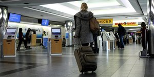 Frau mit Koffer am La Guardia-Flughafen