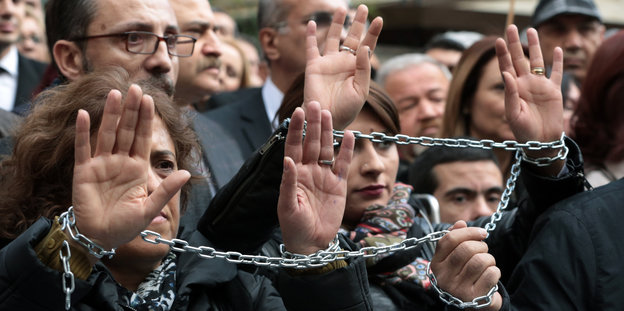 Journalisten protestieren mit Ketten an den Händen gegen die Verhaftung ihrer Kolleginnen.
