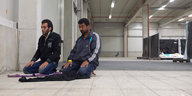 Flüchtlinge knien zum Gebet nieder in einer Ecke ihrer Unterkunft.