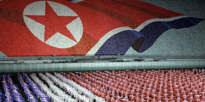Nordkoreaner vor einer riesigen Fahne