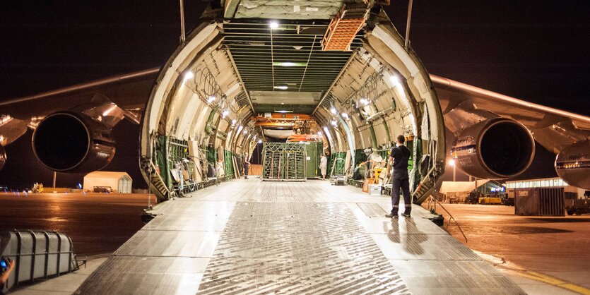 Offene Klappe eines Bundeswehr-Transportflugzeugs bei Nacht auf einem Flugplatz.