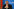 Ansgar Schledde, AfD-Landesvorsitzender in Niedersachsen, sitzt mit gefalteten Händen vor dem Gesicht an einem Rednerpult. Er trägt einen dunklen Anzug und Brille und blickt ernst nach vorn