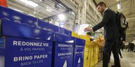Ein Mann recycled Papier in vorgesehene Container