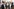 Cem Özdemir und Manuel Hagel vor einem grauen Stehtisch, hinter ihnen auf der Treppe Männer und Frauen. Manuel Hagel fasst dem skeptisch dreinblickenden Cem Özdemir an den Oberarm