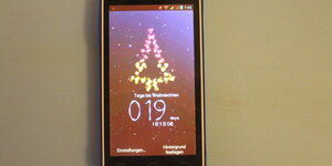 Smartphone-Screen mit stilisiertem Weihnachtsbaum und Schneefall