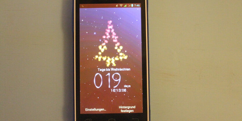 Smartphone-Screen mit stilisiertem Weihnachtsbaum und Schneefall