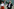 Zoe Garbett und Zack Polanski stehen vor einer Glasfassade.