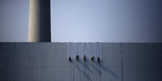 Arbeiter streichen ein Atomkraftwerk in Beijing.
