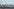 Ein Stacheldrahtzaun im Vordergrund, im Hintergrund sind laufende Menschen