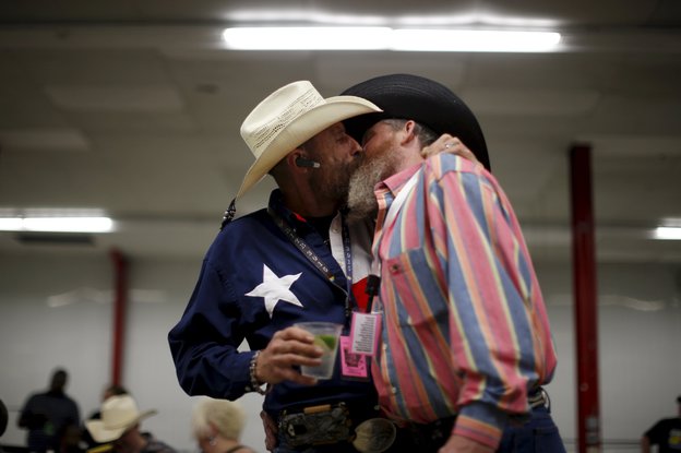 Zwei Cowboys in bunten Hemden küssen sich