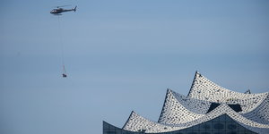 Ein Hubschrauber fliegt an der Elbphilharmonie vorbei