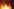 Zwei unscharfe Figuren hinter loderndem Feuer