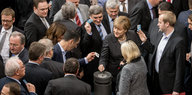 viele Politiker, darunter Angela Merkel, an einer Wahlurne