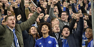 Männer feiern, vorne einer im Schalke-Trikot