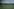 Eine ländliche Landschaft mit einem Strommast auf einer großen Wiese