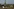 Blick auf das Atomkraftwerk Saporischja in der Ukraine, im Vordergrund eine Strohpuppe in Soldatenuniform und ein Hund