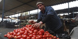 Ein Mann verkauft Tomaten auf dem Markt von Bengasi