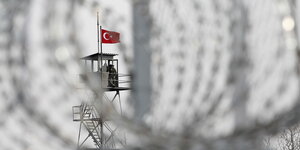 Wachturm mit türkischer Fahne durch Stachdraht fotografiert
