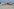 Ein Container ist hinter dem toten Wal am Strand zu sehen