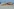 Ein Container ist hinter dem toten Wal am Strand zu sehen