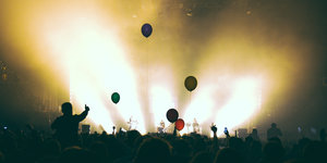 Von Scheinwerfern erhellt, feiert die Menge, Luftballons steigen in die Luft