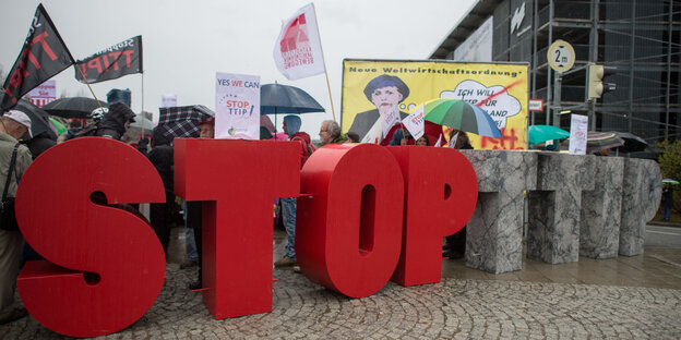 Anti-TTIP-Demonstrant_innen stehen hinter Buchstaben, die „Stop TTIP“ bilden