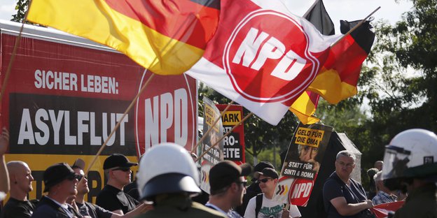 NPD-Anhänger und Polizisten bei einer Demonstration.