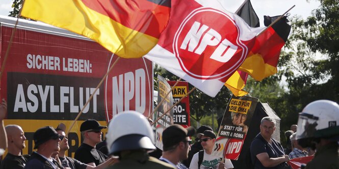 NPD-Anhänger und Polizisten bei einer Demonstration.