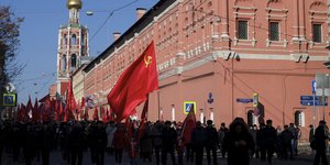 Demonstranten in Moskau, im Vordergrund eine Flagge der Sowjetunion.