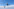 Zwei kleine, markant geformte Windkraftanlagen vor einem hellblauen Himmel mit vereinzelten weißen Wolken