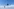 Zwei kleine, markant geformte Windkraftanlagen vor einem hellblauen Himmel mit vereinzelten weißen Wolken