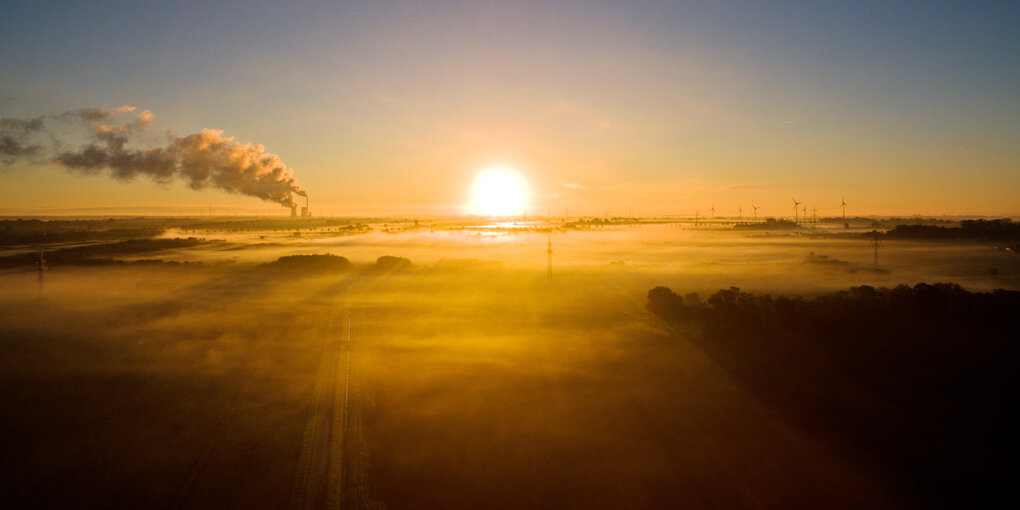 Die Sonne geht auf in Niedersachsen, Landschaft mit Kraftwerken aus fossiler und erneuerbarer Energie