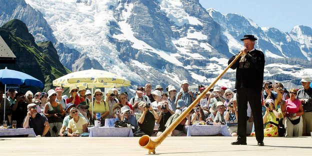 Alphornbläser vor Publikum und Schweizer Bergkulisse