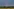 Blitz an dunklem Himmel über Wald und Feldern