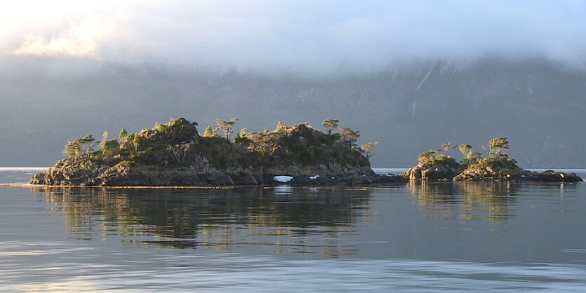 Eine Insel liegt in schimmerndem Wasser