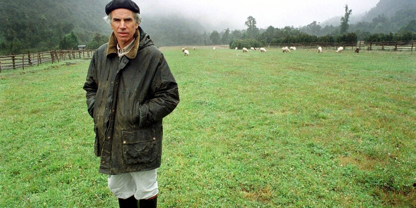 Douglas_Tompkins_steht_mit_Gummistiefeln_auf_einer_Schafsweide