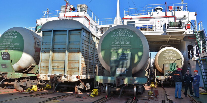 Auf einem Schiff stehen mehrere Eisenbahnwaggons