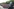 Ein Demonstrationszug, die Menschen inder ersten Reihe halten ein großes Banner: Eine lebenswerte Zukunft Generation Antifa widersetzen - vor ihnen steht ein Polizist in v oller Montur