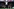 Während des Spiels steht Stolbakken mit entspannt eingehängten Armen und überkreuzten Beinen vor der Bank
