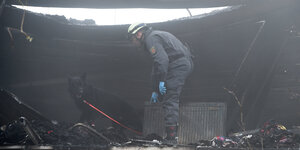 Ein Feuerwehrmann in dem ausgebrannten Gebäude.