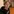 Eine junge Frau mit kurzen blonden Haaren und Brille in einem schwarzen Hoodie