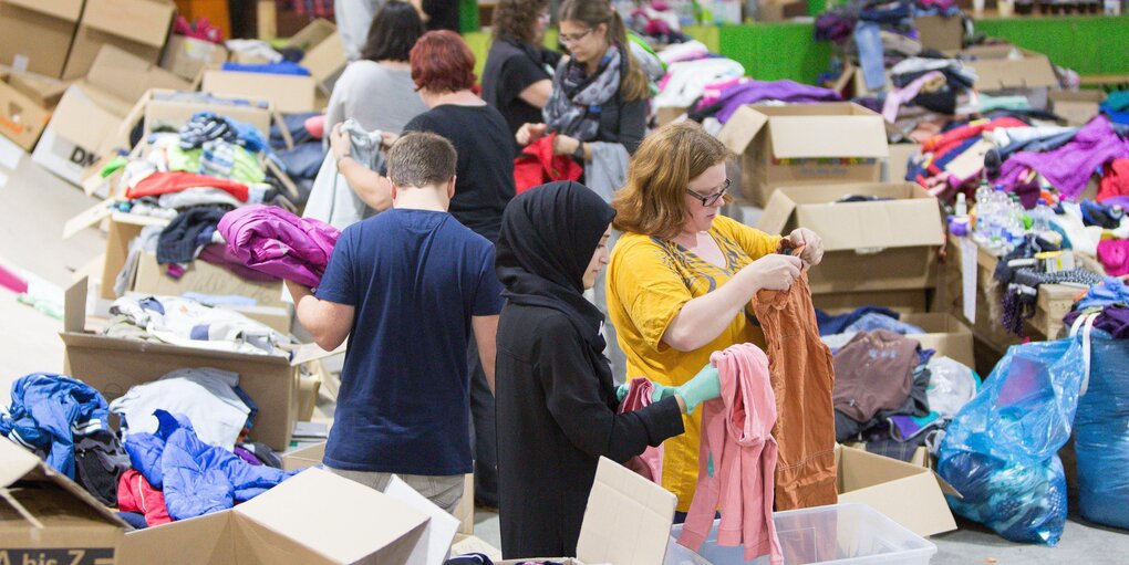 Flüchtlingshelfer sortieren Kleidung