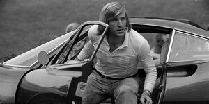 Schwarz-weiß-Foto von Günter Netzer, der einem Ferrari entsteigt